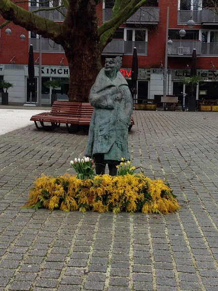 Statue at Rabbijn Maarsenplein with flowers